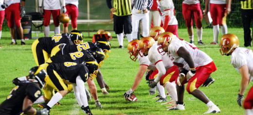 The opposing teams line up at the line of scrimmage before play begins with the snap of the football.