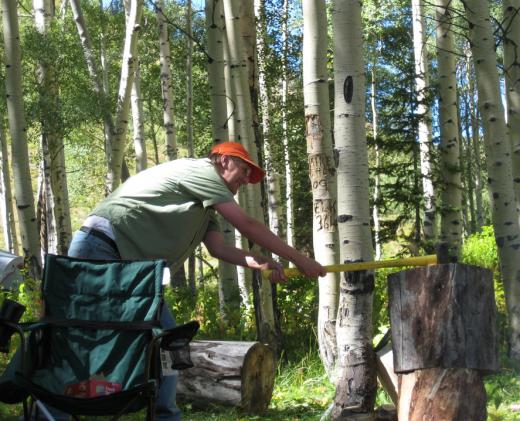 A man using an axe to chop wood.