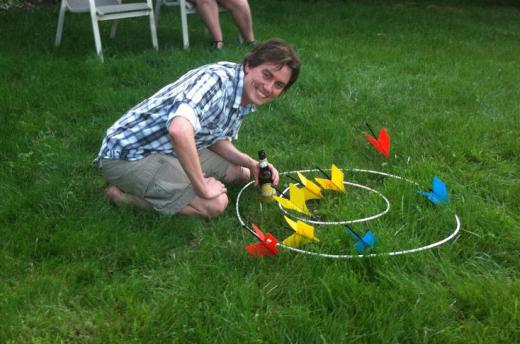 The game of lawn darts involves tossing large darts into circular targets.